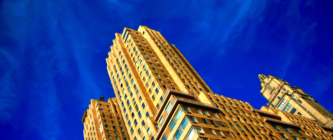 yellow skyscraper building against blue sky