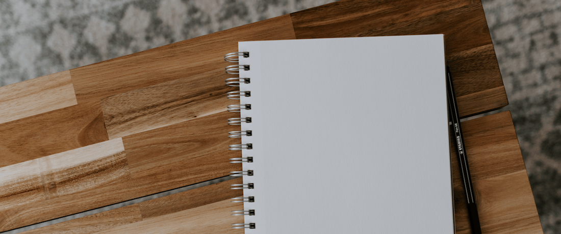 blank notebook on a wooden desk
