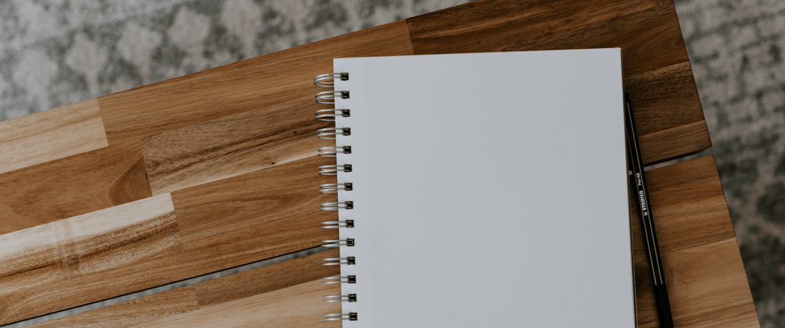 blank notebook on a wooden desk