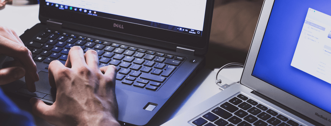 man using two laptops